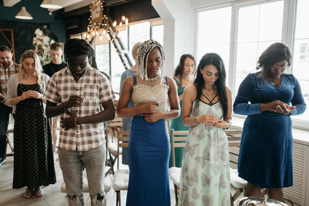 Grupa dorosłych różnych wyznań modli się wspólnie w sali Grupa dorosłych różnych wyznań modli się wspólnie w sali