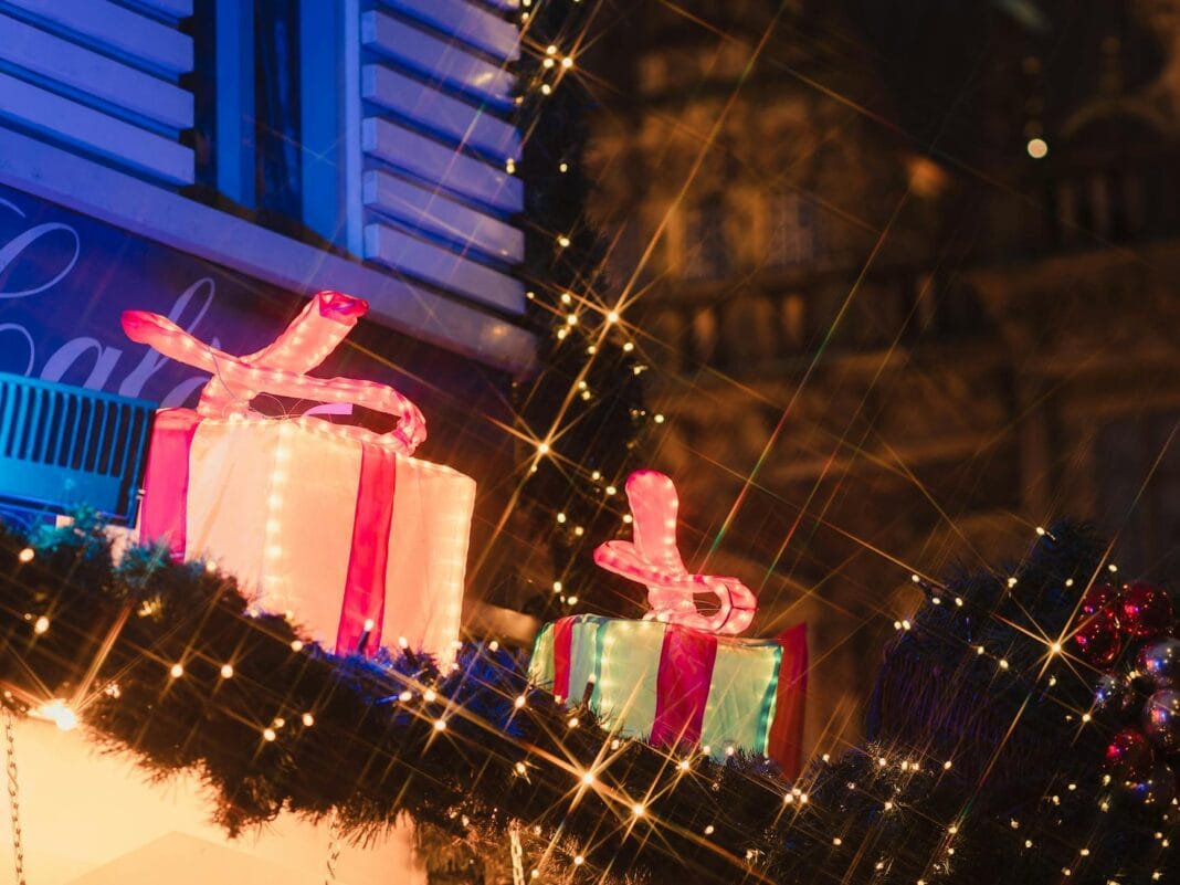 Oświetlone prezenty na nocnym niemieckim jarmarku bożonarodzeniowym