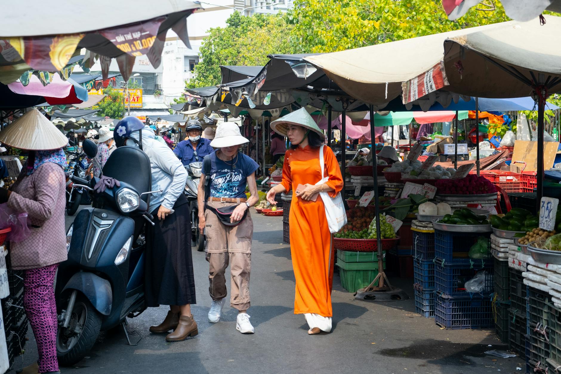 Targ uliczny w Ho Chi Minh z kolorowymi stoiskami i kupującymi