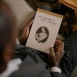 Mężczyzna w garniturze czyta Cierpienia młodego Wertera w eleganckim wnętrzu