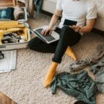 Wiza, ubezpieczenie i szczepienia do Peru: wszystko, co warto ogarnąć przed wyjazdem Mężczyzna pakuje walizkę na podłodze, planując wyjazd do Peru na laptopie