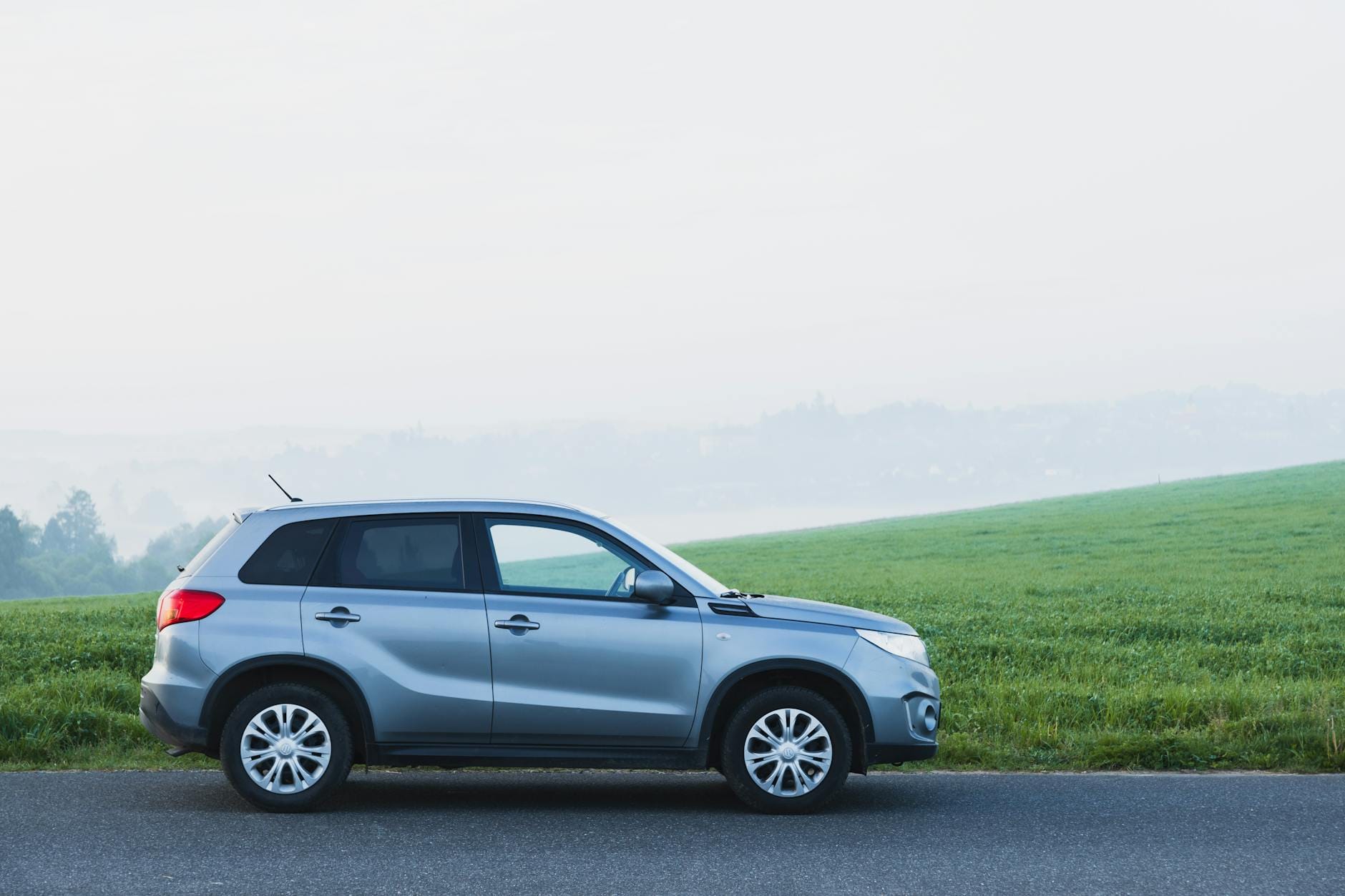 Srebrny SUV zaparkowany we mgle na wiejskiej drodze w Czechach