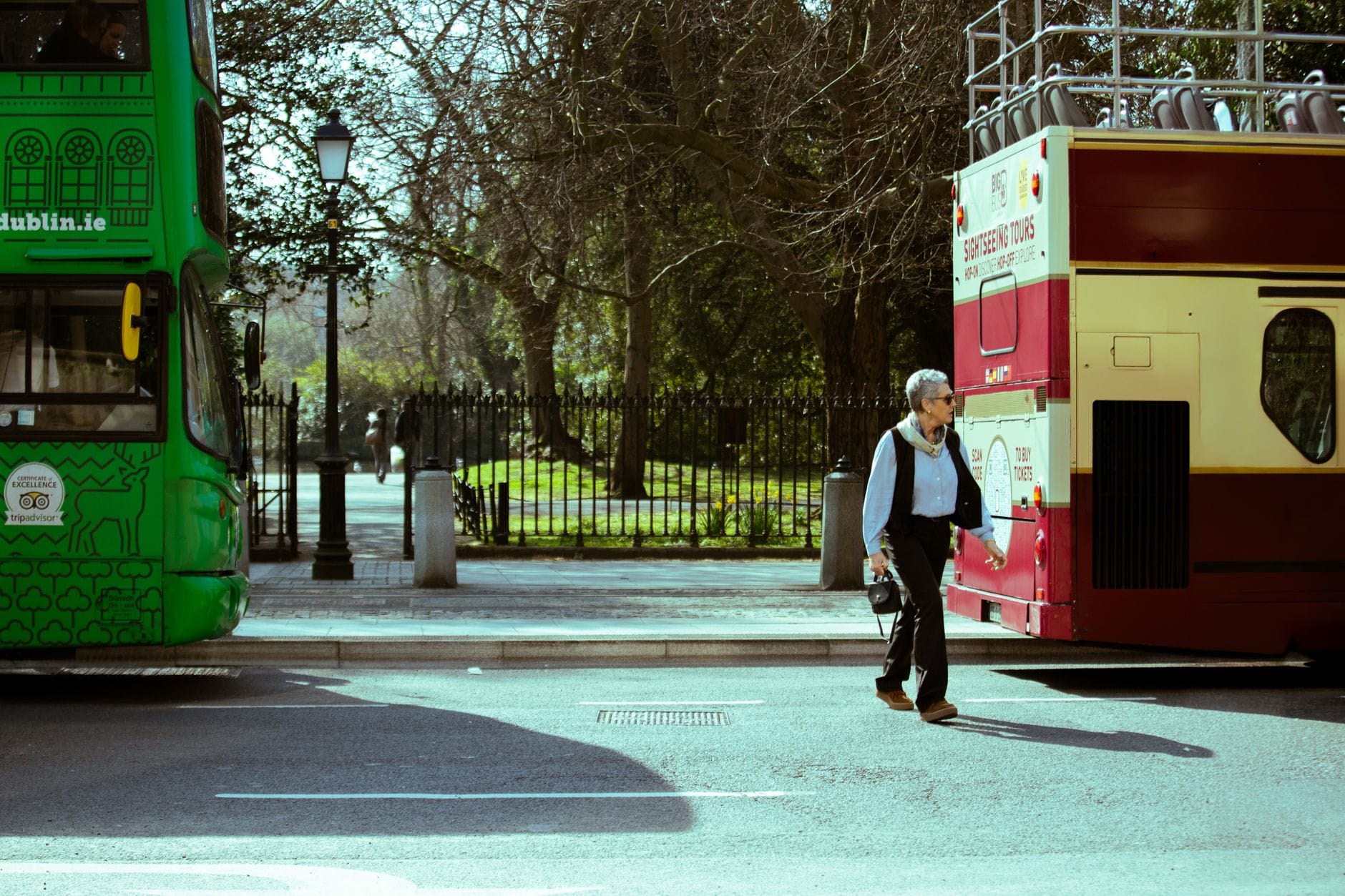 Trasa po Dublinie śladami literatury: Joyce, Wilde i klimatyczne księgarnie Mężczyzna idzie między autobusami turystycznymi na ulicy w Dublinie